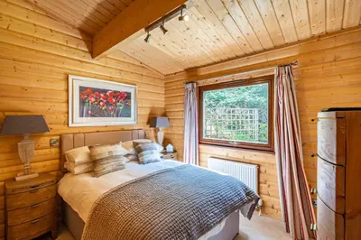 a bedroom with a bed in a wooden cabin at Screel View in Kippford