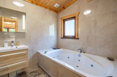 a large bathroom with a tub and a sink at Screel View in Kippford