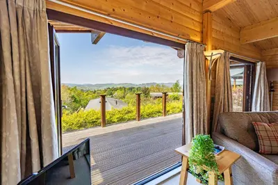 a living room with a large window and a couch at Screel View in Kippford