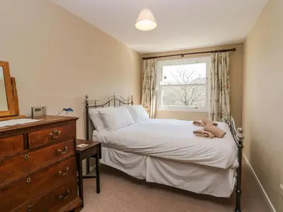 a bedroom with a bed with a teddy bear on it at Fellside View in Ambleside