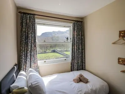 a bed in a room with a large window at Fellside View in Ambleside