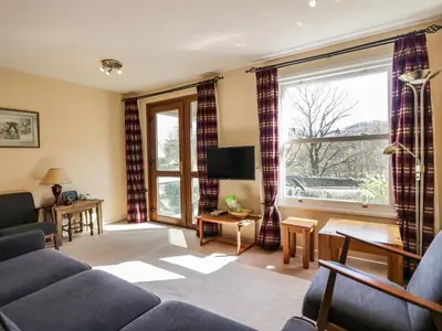 a living room with a couch and a large window at Fellside View in Ambleside