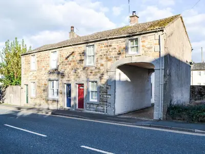 an old brick building with an arch over a street at Willow Cottage in Cockermouth