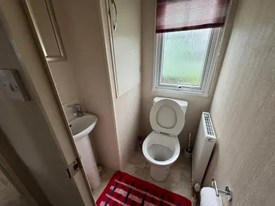 a small bathroom with a toilet and a sink at Coyles retreat in Stranraer