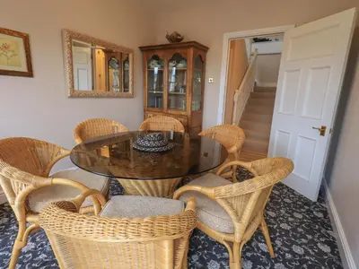 a dining room with a table and wicker chairs at Peak View in Keswick