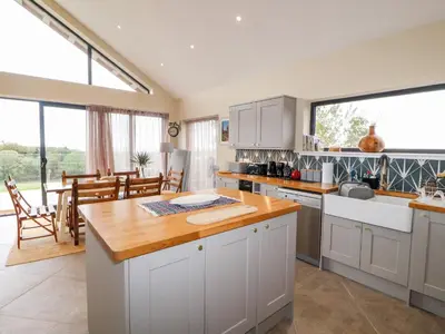 a kitchen with white cabinets and a large window at The Lodge in Stranraer