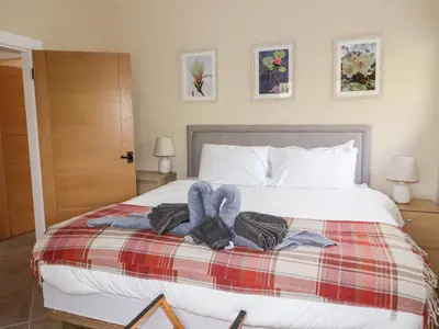 a bedroom with a bed with towels on it at The Lodge in Stranraer