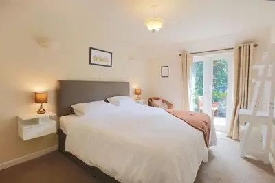 a bedroom with a large white bed and a window at Silver Lodge in Creetown