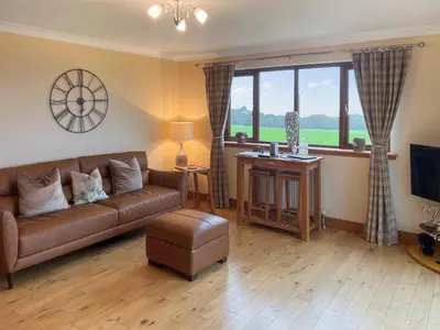 a living room with a couch and a large window at Trelaw - Uk41532 in Cumnock