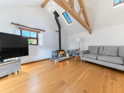 a living room with a couch and a fireplace at Swallow Barn in Cockermouth