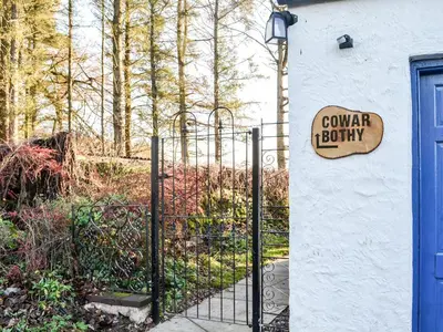 a sign on a gate in front of a house at Cowar Bothy in Dalbeattie
