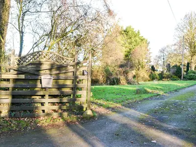 a wooden fence on the side of a road at Cowar Bothy in Dalbeattie