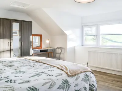 a bedroom with a bed and a desk at Cowar Bothy in Dalbeattie