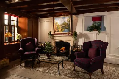 a living room with two chairs and a fireplace at Brig o' Doon House Hotel in Ayr