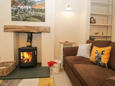 a living room with a couch and a fireplace at Derwent Cottage in Keswick
