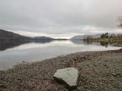 a rock sitting on the shore of a body of water at Derwent Cottage in Keswick