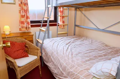 a bedroom with a bunk bed and a chair and a bed at Links Quay 42 in Prestwick