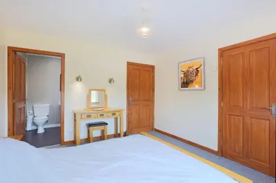 a bedroom with a bed and a table and a desk at Croftdean in East Barcloy