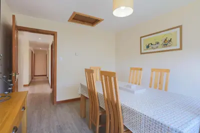 a dining room with a table with chairs and a blue and white at Croftdean in East Barcloy