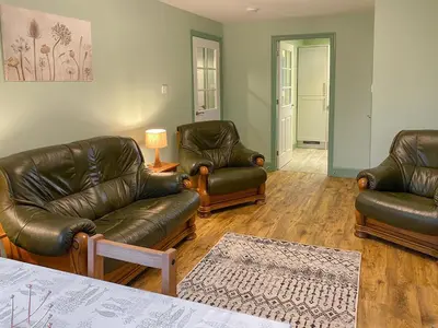 a living room with leather furniture and a table at Ardwell Park in Ardwell