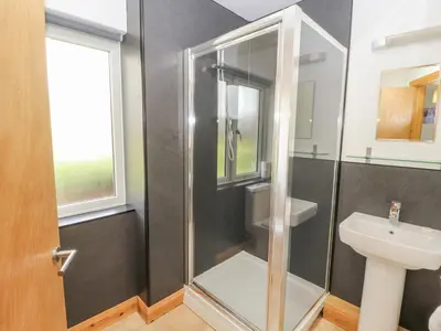 a bathroom with a shower and a sink at Old School Muncaster House in Ravenglass