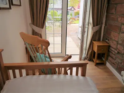 a room with a table and two chairs and a window at Laurieknowe Coach House in Dumfries