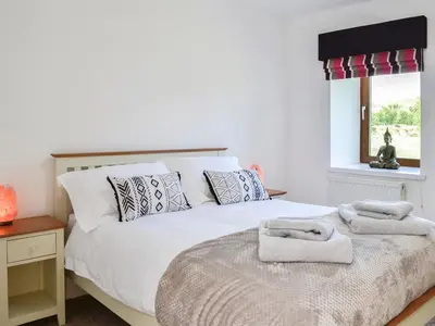 a bedroom with a bed with towels on it at The Byre - Camp Douglas - Cottage in Crossmichael