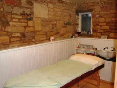 a bedroom with a bed and a sink in a stone wall at The Bird Bath - Cottage in Wreay