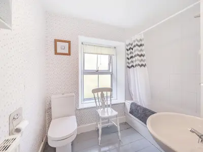 a bathroom with a toilet and a sink and a chair at High Rakes in Glenridding