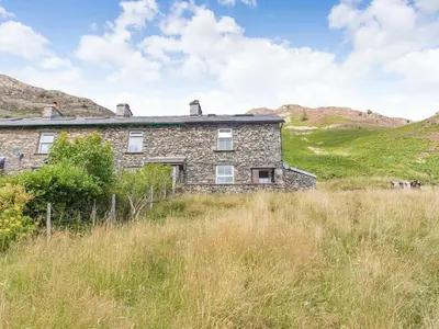 an old stone house in the middle of a field at High Rakes in Glenridding
