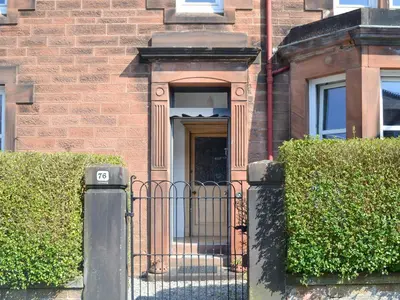 a gate in front of a brick building at Cardoness Houses in Dumfries