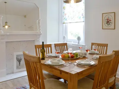 a dining room with a wooden table with wine glasses at Cardoness Houses in Dumfries