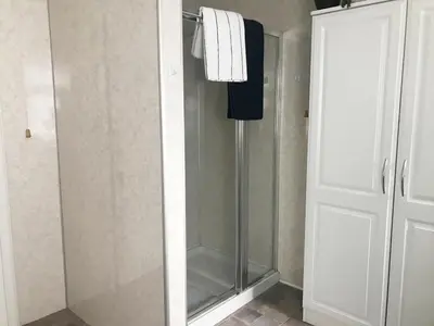 a shower with a glass door in a bathroom at Cardoness Houses in Dumfries