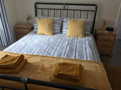 a bedroom with a bed with two towels on it at Curlew Cottage and Sunset View in Port Logan
