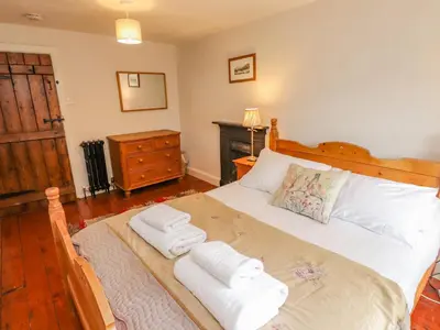 a bedroom with a large bed with towels on it at Fir Tree Cottage in Ambleside