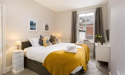 a bedroom with a large bed with a yellow blanket at Thirty Blencathra Street in Keswick