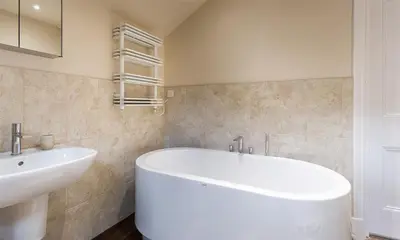 a bathroom with a white tub and a sink at Thirty Blencathra Street in Keswick