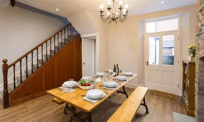 a dining room with a table and a chandelier at Thirty Blencathra Street in Keswick