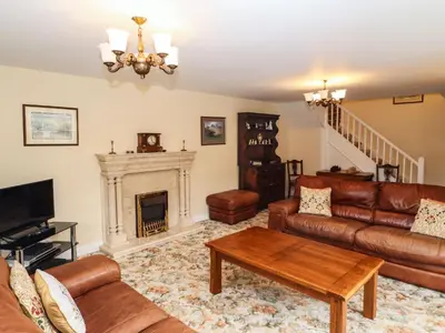 a living room with leather furniture and a fireplace at Pavement End Cottage in Grasmere