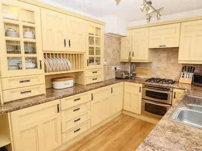 a kitchen with white cabinets and a sink at Pavement End Cottage in Grasmere