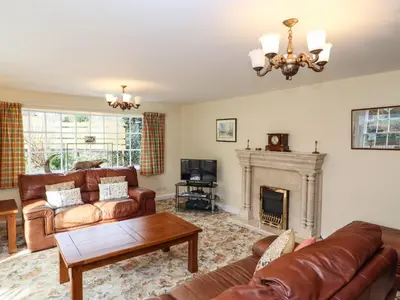 a living room with leather furniture and a fireplace at Pavement End Cottage in Grasmere