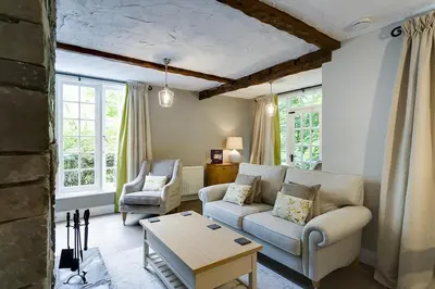 a living room with a couch and two chairs at Acorn Cottage in Grasmere