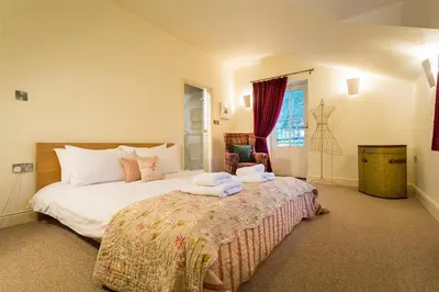 a bedroom with a large bed with towels on it at Thimble Hall in Grasmere