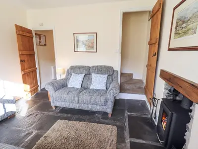 a living room with a couch and a fireplace at Slaters Rest in Chapel Stile