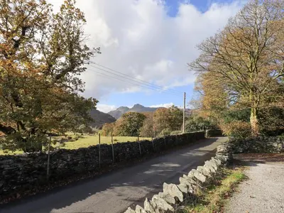 a road with a stone fence next to a field at Slaters Rest in Chapel Stile