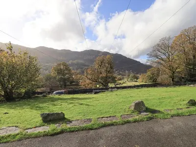 a field of green grass with mountains in the background at Slaters Rest in Chapel Stile