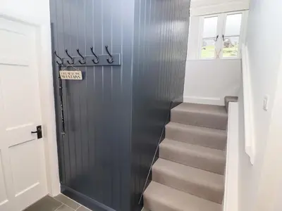a stairway with a gray door and a stair case at Tilly's Cottage in Grasmere