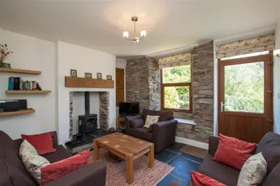 a living room with couches and a fireplace at Robins Nest in Coniston