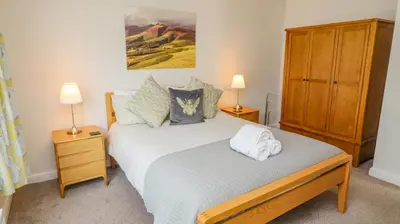 a bedroom with a bed with two night stands and two lamps at Bowderstone in Keswick