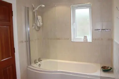 a bathroom with a bath tub and a window at Bandol in Braithwaite